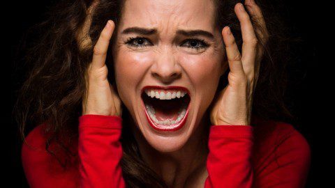 Angry, desperate woman screaming Close-up of a very angry, upset and desperate woman screaming