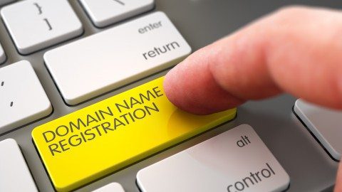 Close Up view of Male Hand Touching Yellow Domain Name Registration Computer Keypad. 3D.